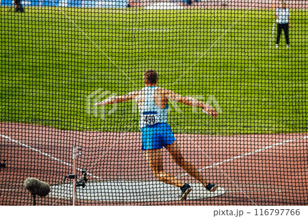 discus throw, male athlete makes an attempt, view through grid 116797766