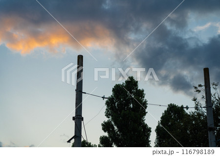 Poles of power lines against the background of sunset clouds Poles of power lines against the background of sunset clouds 116798189
