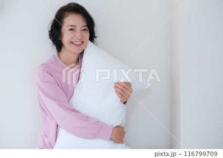 枕を抱えて心を体を整えるミドル女性 116799709