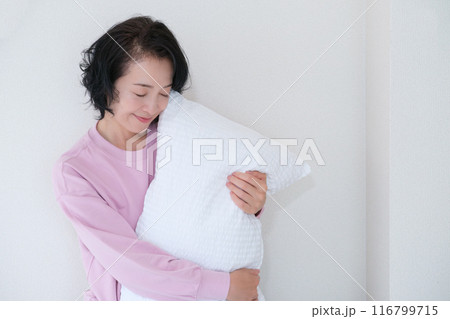 枕を抱えて心を体を整えるミドル女性 116799715