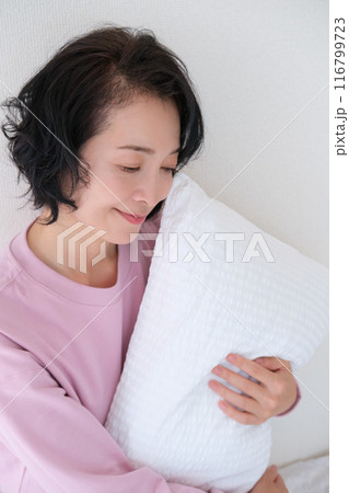 枕を抱えて心を体を整えるミドル女性 116799723