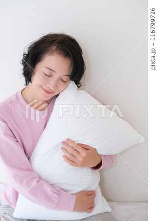 枕を抱えて心を体を整えるミドル女性 116799726