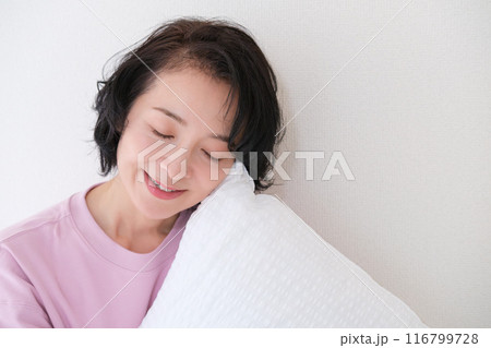 枕を抱えて心を体を整えるミドル女性 116799728