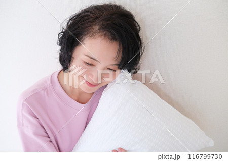 枕を抱えて心を体を整えるミドル女性 116799730