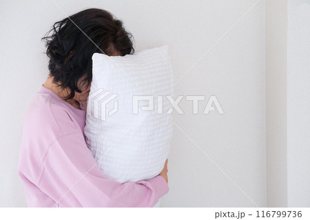 枕を抱えて心を体を整えるミドル女性 116799736