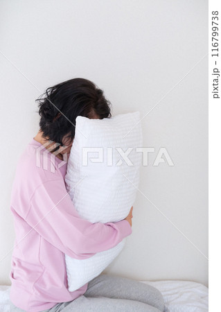 枕を抱えて心を体を整えるミドル女性 116799738