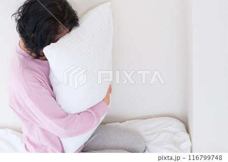 枕を抱えて心を体を整えるミドル女性 116799748