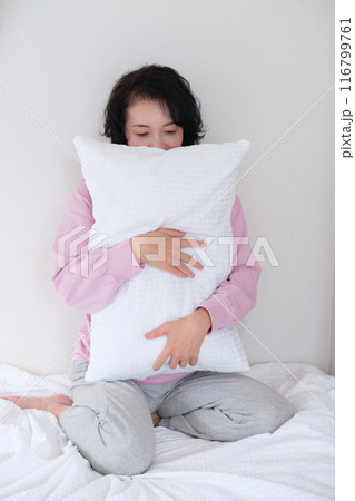 枕を抱えて心を体を整えるミドル女性 枕を抱えて心を体を整えるミドル女性 116799761