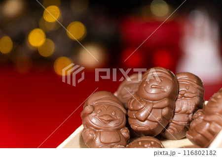 Chocolates in the shape of Christmas figures on the background of a flashing garland Chocolates in the shape of Christmas figures on the background of a flashing garland 116802182