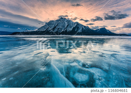Natural bubbles frost on frozen Abraham Lake with rocky mountains in winter at Canada Natural bubbles frost on frozen Abraham Lake with rocky mountains in winter at Canada 116804681