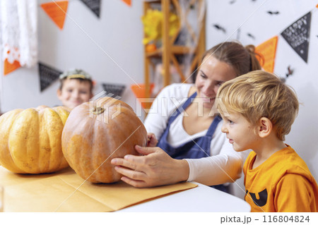Woman and Children Painting Halloween Pumpkins 116804824