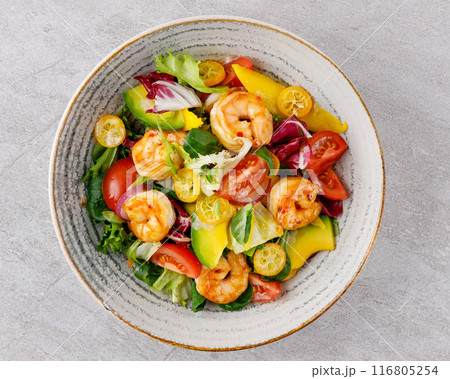 Salad with shrimps in sweet and sour sauce with mango and avocado. on a gray background Salad with shrimps in sweet and sour sauce with mango and avocado. on a gray background 116805254