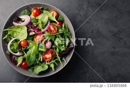 Green Salad With Tomatoes and Onions in a Black Bowl 116805866