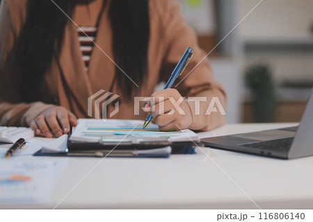 Business woman accountant working audit and calculating expense financial annual financial report balance sheet statement, doing finance making notes on paper checking document. Business woman accountant working audit and calculating expense financial annual financial report balance sheet statement, doing finance making notes on paper checking document. 116806140