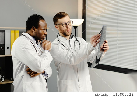 Two men in white lab coats analyzing xray Two men in white lab coats analyzing xray 116806322