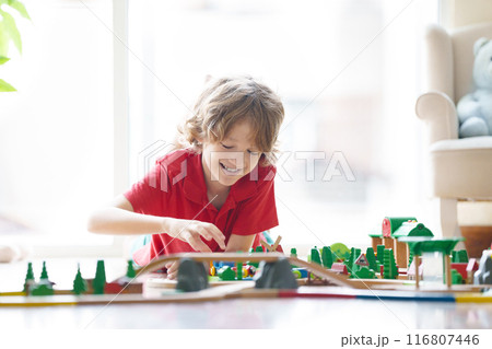 Kids play wooden railway. Child with toy train. 116807446