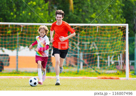 Child playing football. Kids play soccer. 116807496