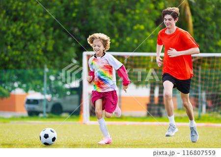 Child playing football. Kids play soccer. 116807559