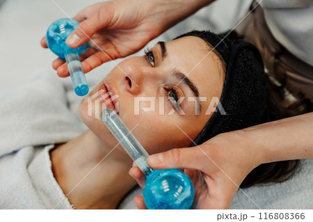 The master gives the client a relaxing facial massage using cold cryo spheres. The master gives the client a relaxing facial massage using cold cryo spheres. 116808366