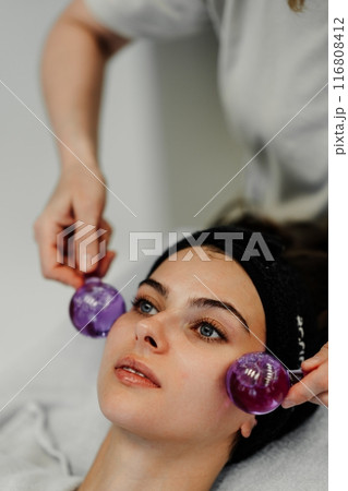 The master gives the client a relaxing facial massage using cold cryo spheres. 116808412