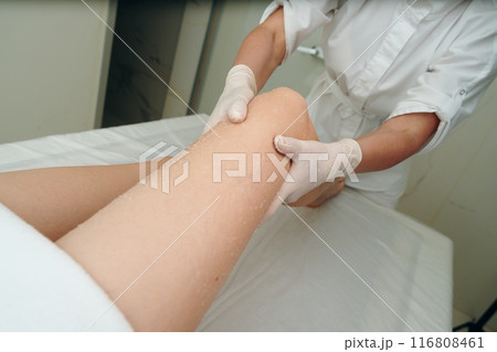 A woman gets a foot massage in a beauty salon. 116808461