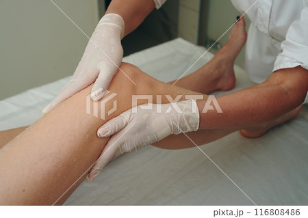 A woman gets a foot massage in a beauty salon. 116808486