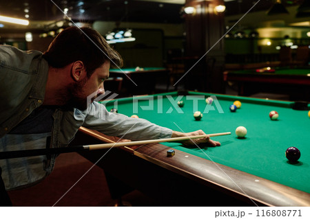 Bending over table with billiards balls 116808771