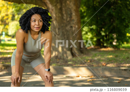 Woman exercising in a park and having a short pause 116809039