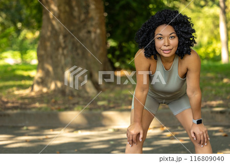 Woman exercising in a park and having a short pause 116809040