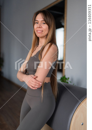 Pilates fitness trainer in pilates studio. Young sporty attractive woman wearing sportswear in yoga studio. Fit, healthy and strong authentical body. Fitness concept Pilates fitness trainer in pilates studio. Young sporty attractive woman wearing sportswear in yoga studio. Fit, healthy and strong authentical body. Fitness concept 116809351