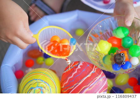 小学生の子供が庭でボールすくいを楽しんでいる様子。 小学生の子供が庭でボールすくいを楽しんでいる様子。 116809437