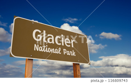 Glacier National Park (Montana) Road Sign Against Blue Sky and Clouds. Glacier National Park (Montana) Road Sign Against Blue Sky and Clouds. 116809743