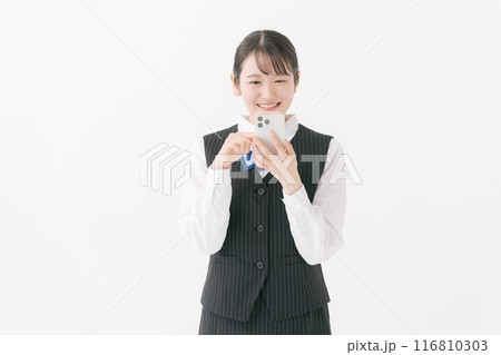 スマホを持つ笑顔の制服の女性 116810303