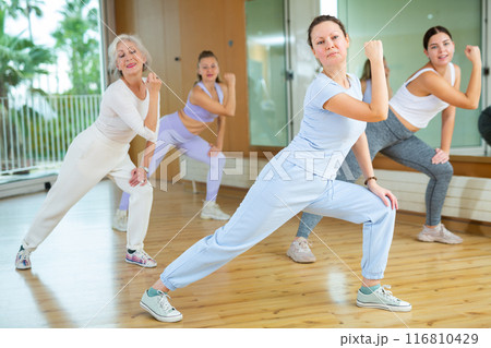 Active middle-aged woman practicing aerobic dance in training hall Active middle-aged woman practicing aerobic dance in training hall 116810429
