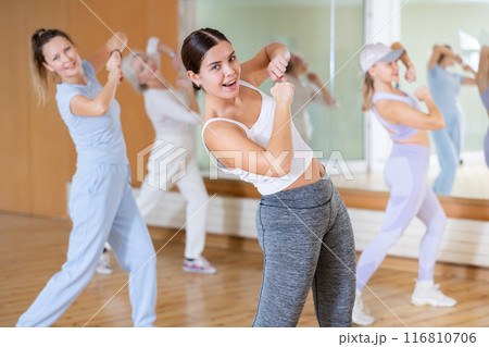 Active young woman practicing aerobic dance in training hall 116810706