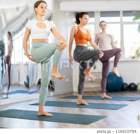 Girl teacher lead yoga lesson for girls and doing Utchicha Hasta padangusthasana. Girl teacher lead yoga lesson for girls and doing Utchicha Hasta padangusthasana. 116810784