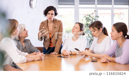 Hispanic woman discussing with group of female coursemates Hispanic woman discussing with group of female coursemates 116810824