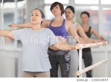Elderly woman standing in second position in beginner ballet class Elderly woman standing in second position in beginner ballet class 116810847