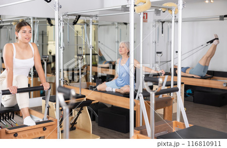 Concentrated young girl practicing exercises on Pilates reformer 116810911