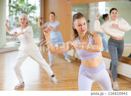 Positive people practicing vigorous lindy hop movements in dance class 116810941