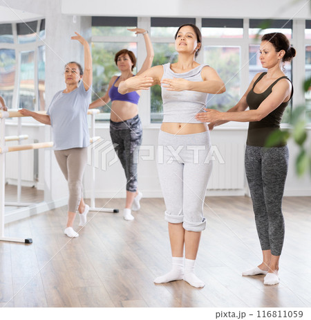 Ballet lesson for amateurs - choreographer teaches women of different ages different ballet steps in studio 116811059