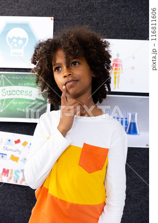 African american schoolboy in school classroom with chemistry posters in background African american schoolboy in school classroom with chemistry posters in background 116811606