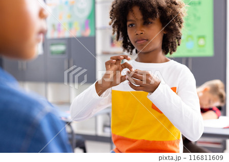 Happy diverse schoolchildren using sign language in school classroom 116811609
