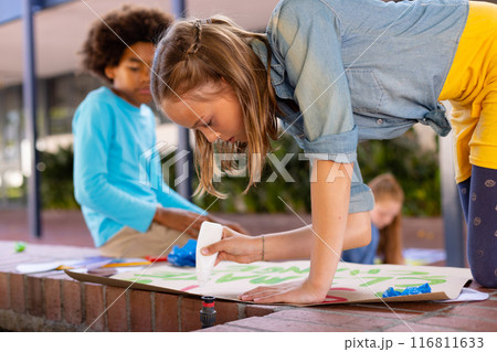 Happy diverse schoolchildren making ecology posters during outdoor school art class 116811633