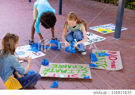 Happy diverse schoolchildren making ecology posters during outdoor school art class 116811635