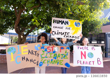 Happy diverse schoolchildren holding ecology posters made in art class outside school Happy diverse schoolchildren holding ecology posters made in art class outside school 116811650