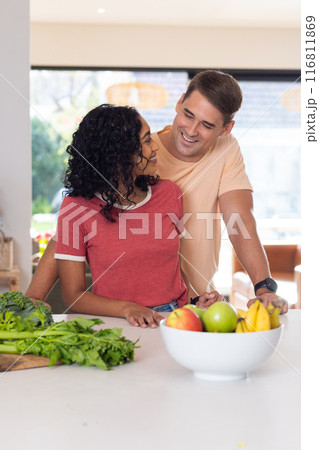 Smiling young couple preparing healthy meal with fresh vegetables in kitchen 116811869