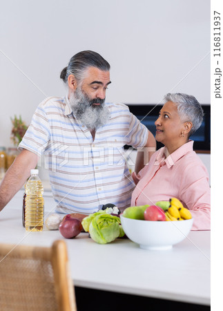 Senior couple in kitchen, preparing healthy meal with fresh vegetables and fruits 116811937