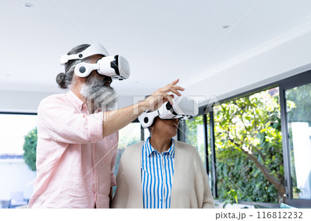 Using VR headsets, senior couple exploring virtual reality experience together 116812232
