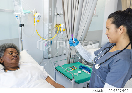 Nurse prepares medication for a senior African American woman in a hospital Nurse prepares medication for a senior African American woman in a hospital 116812460